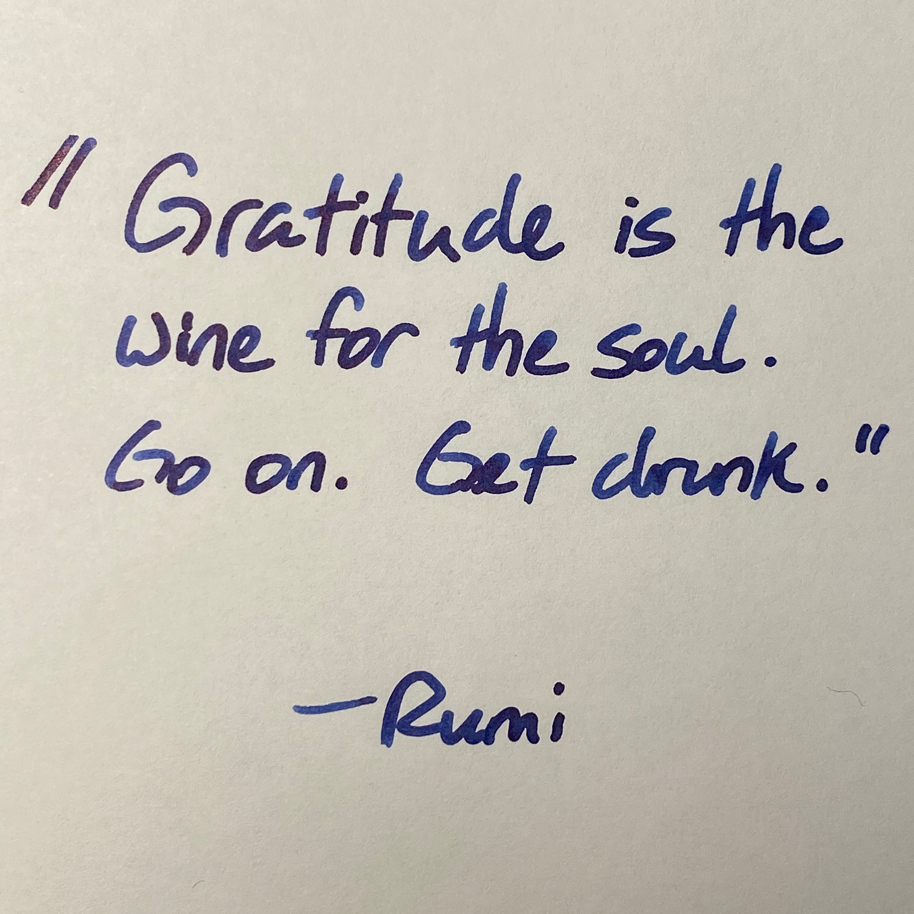 Handwritten note in blue ink by Rumi: Gratitude is the wine for the soul. Go on. Get drunk.