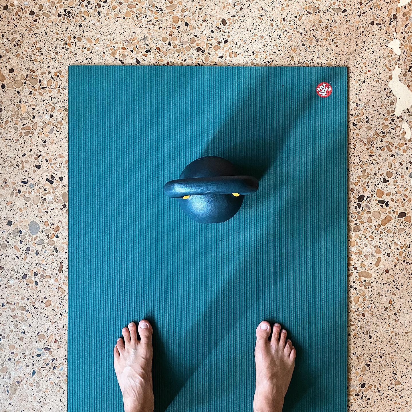 16kg kettlebell on Manduka yoga mat, feet standing on mat